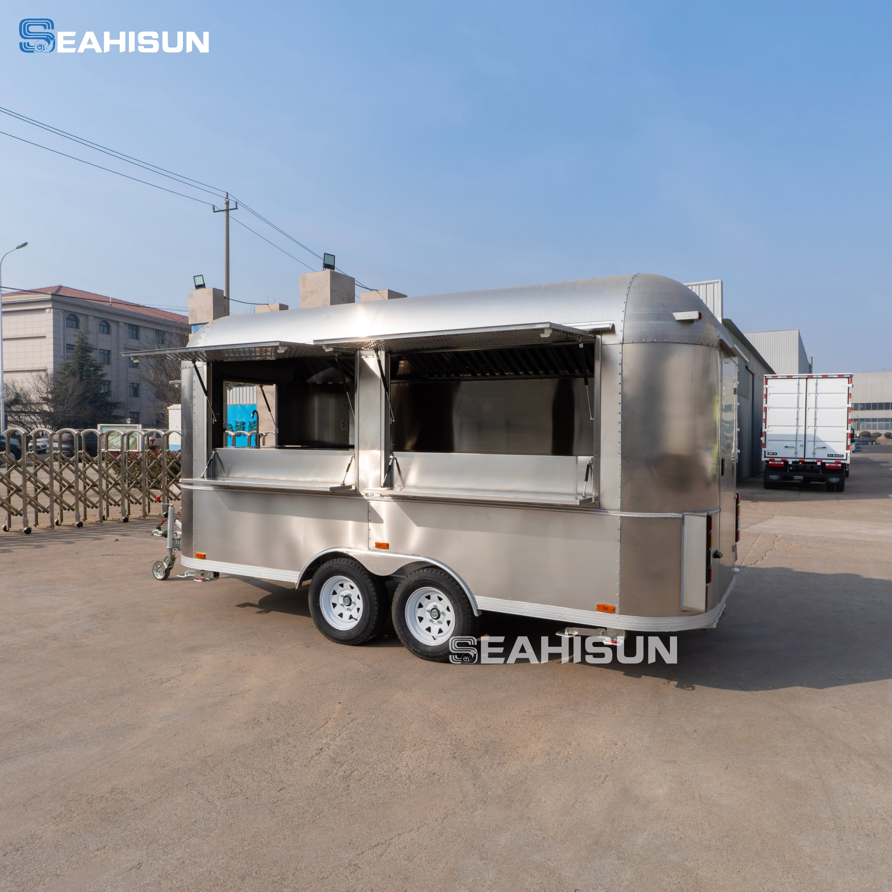 A commercial food trailer interior showing stainless steel prep stations and high-volume refrigeration setup